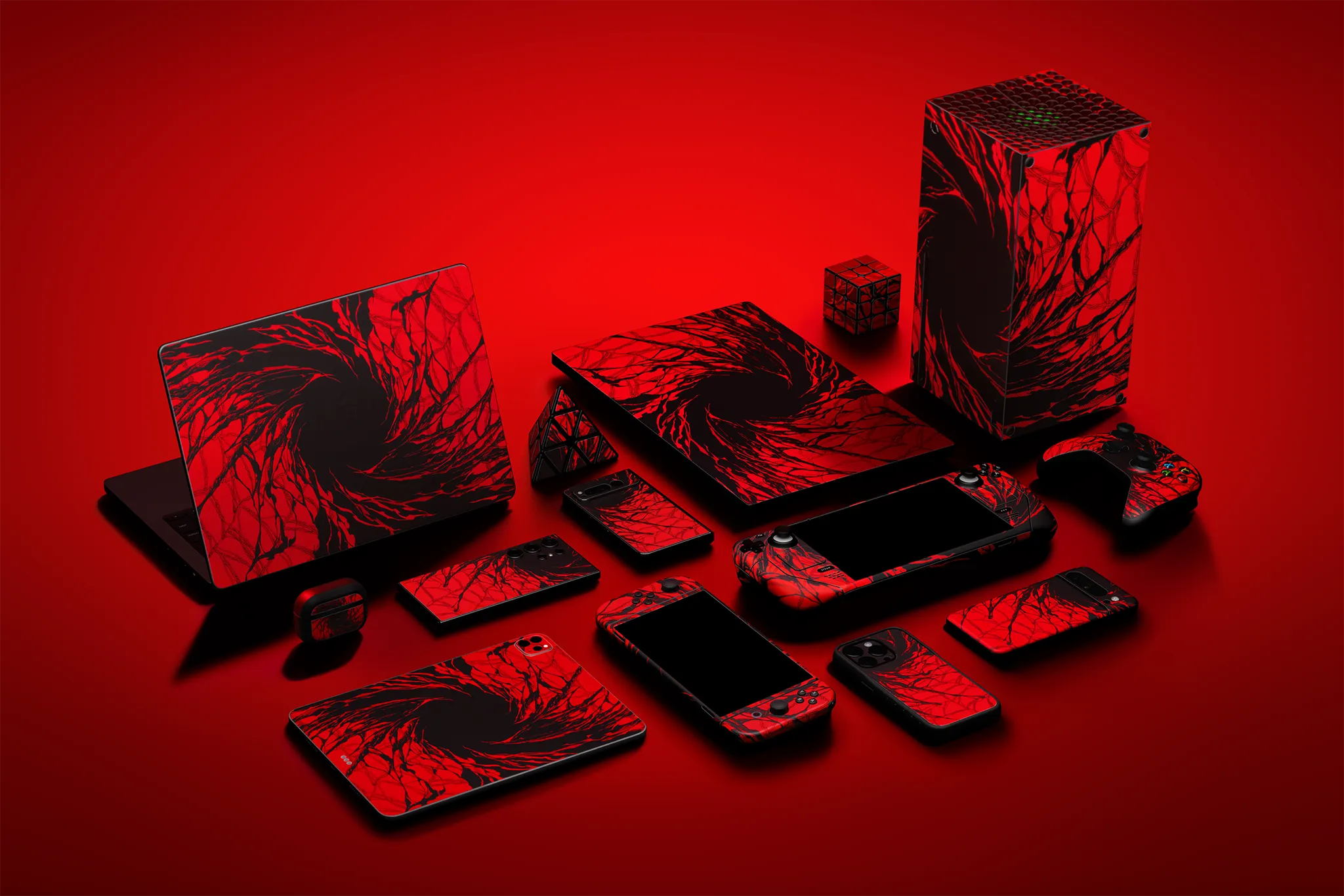 A variety of tech devices (iPhones, Samsung phones, and laptops), all skinned in our Carnage material on a red backdrop.
