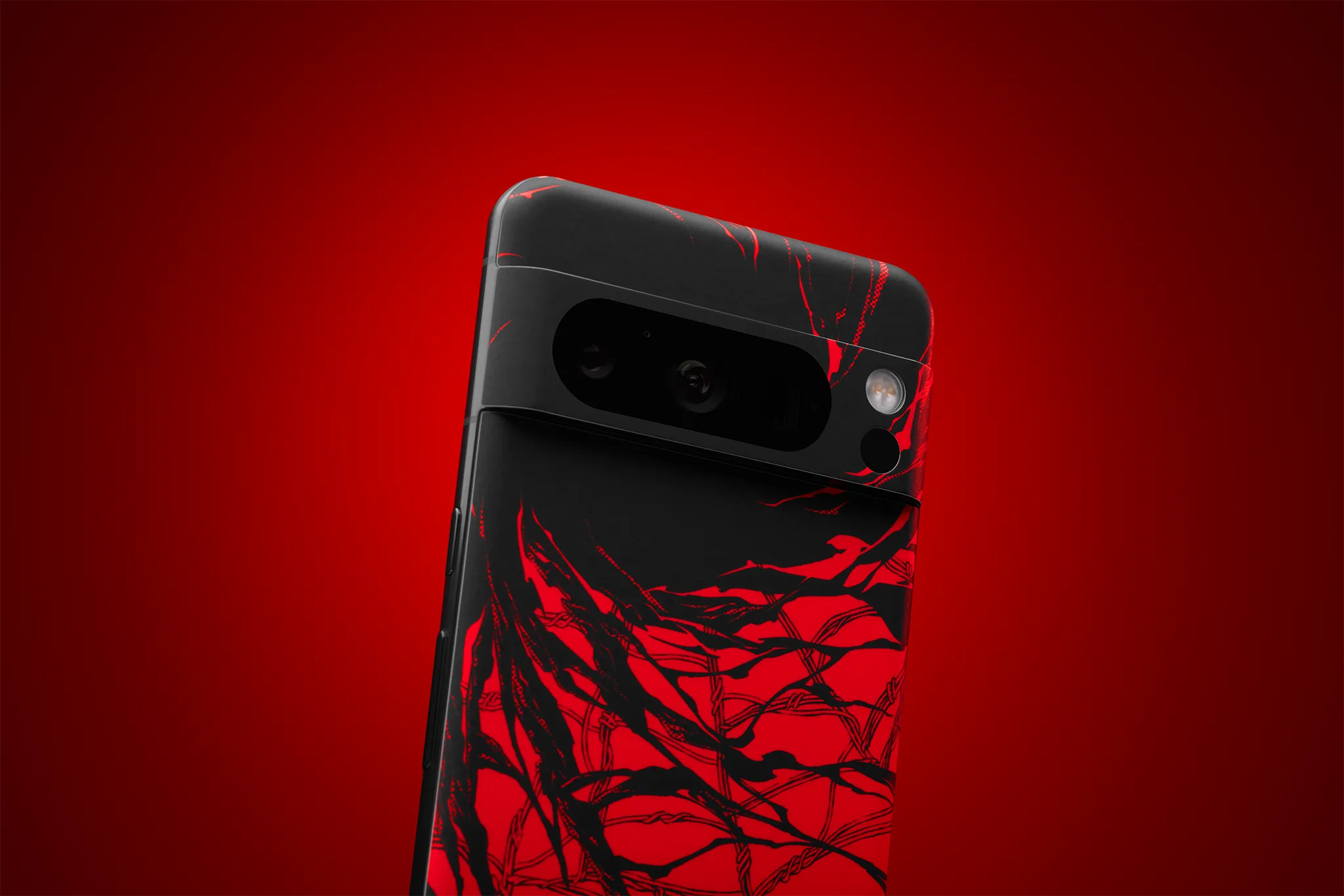 A Pixel 8 Pro with the back facing the viewer, against a red backdrop. Our Carnage Skin is applied, covering the full back surface of the device and the camera bar.