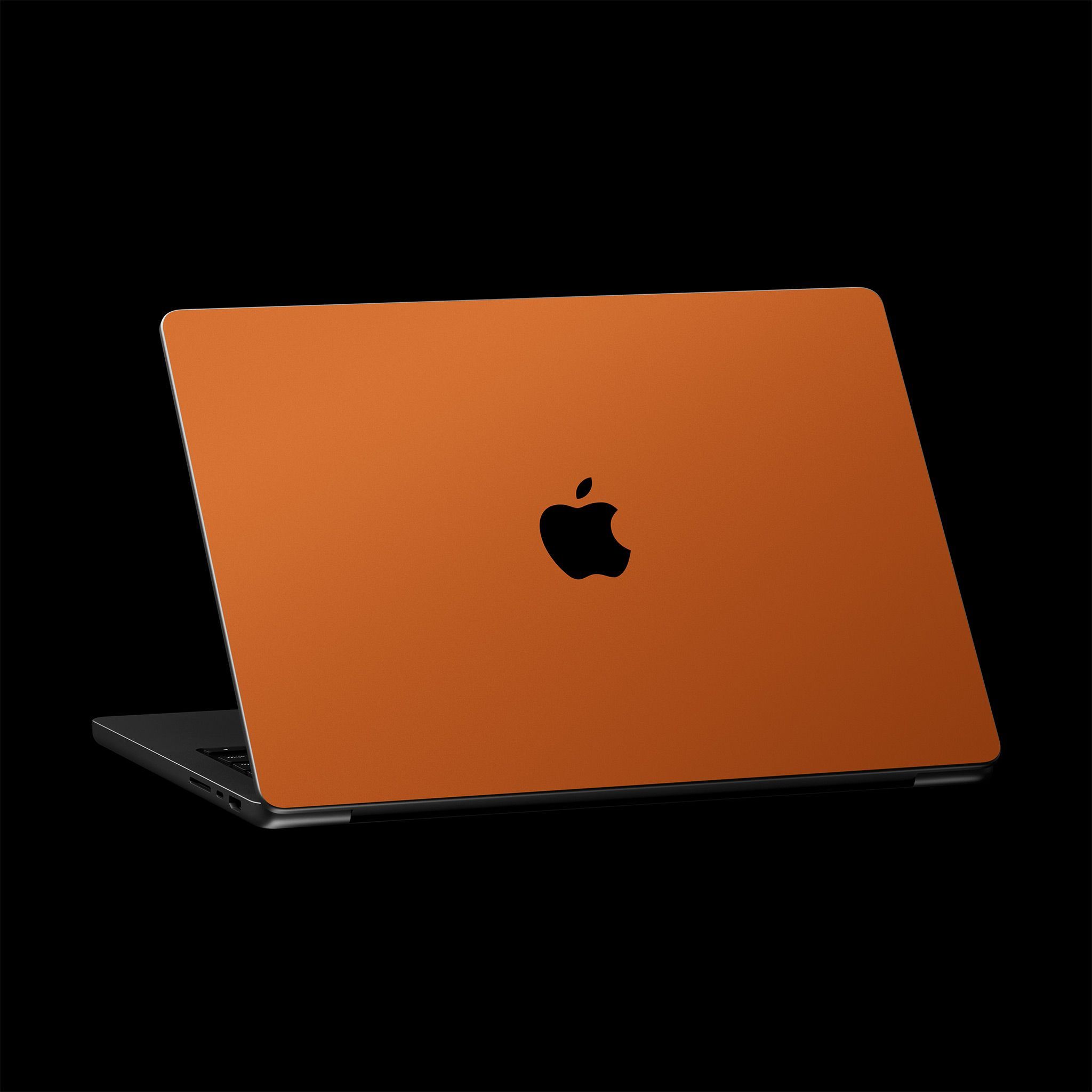 A half-open MacBook, with the lid facing the viewer.  The top lid is skinned with a Cosmic Orange Skin, covering the entire surface except for the logo.