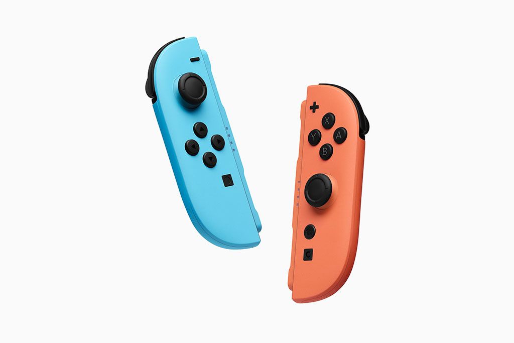 Two Joy-Cons. Each one has a dbrand Colormatched Skin applied to it. The left is blue, and the right is orange. 