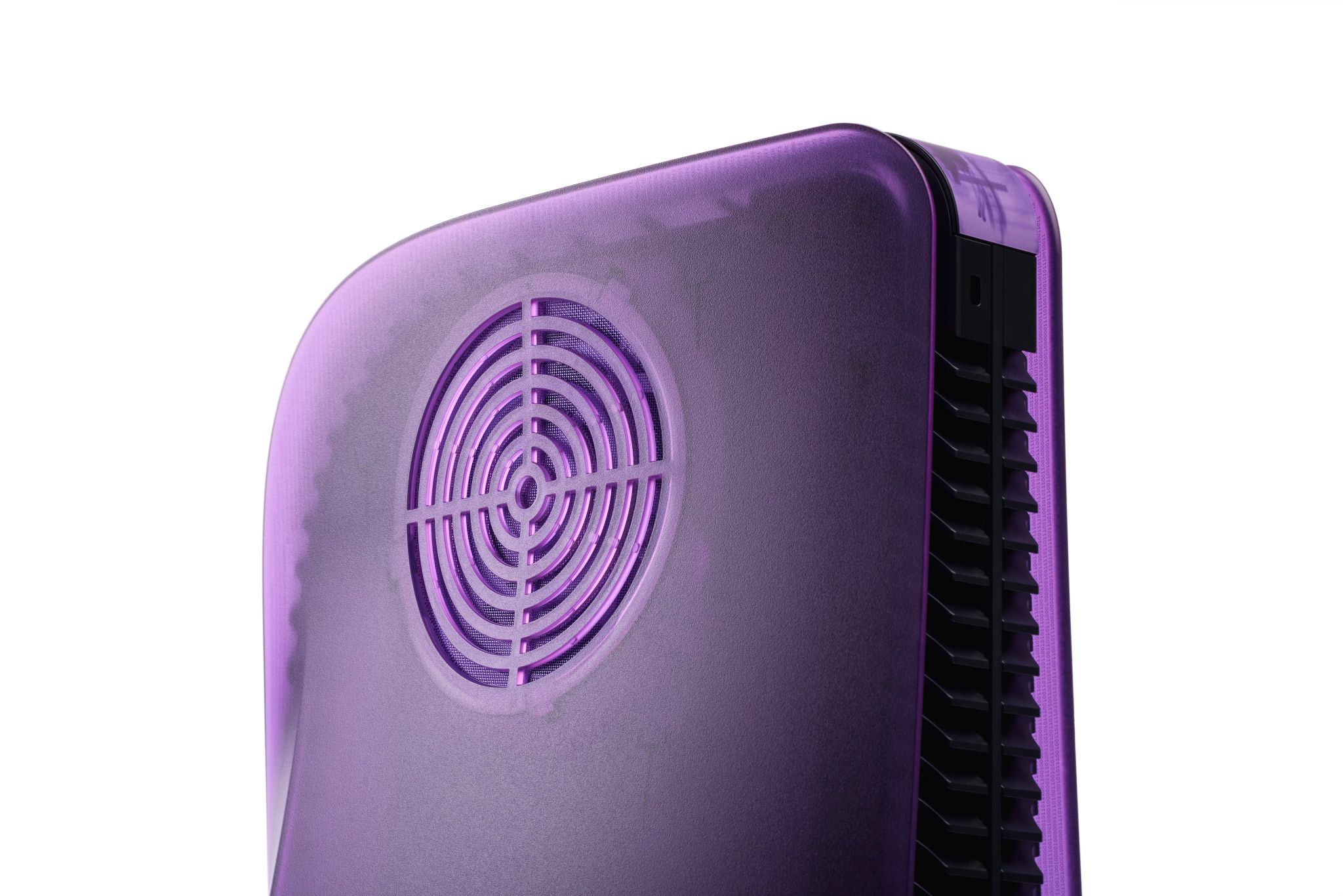 A PlayStation 5 Console seen from a back angle, with the right side of the console clearly visible. Our Atomic Purple Darkplates are replacing the original panels, with a vent clearly displayed by the top.